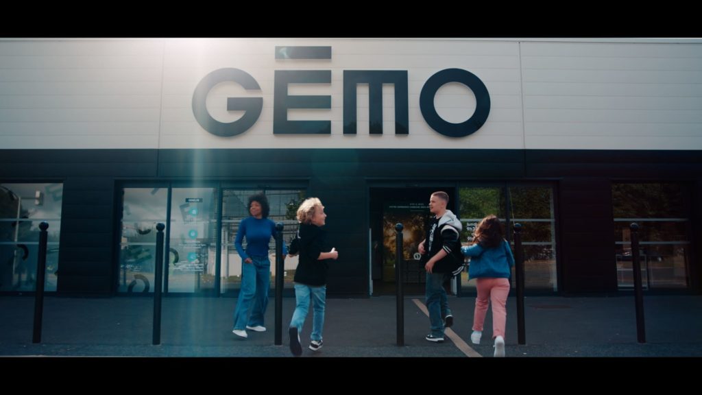 Les chanteurs The Voice Kids courent en direction du magasin Gémo. Cette image est extrait du clip.