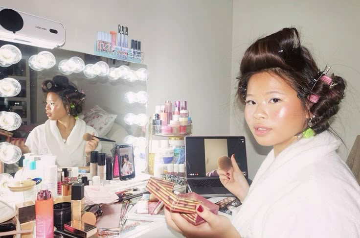 Katie Fang présentant des produits de beauté devant sa coiffeuse